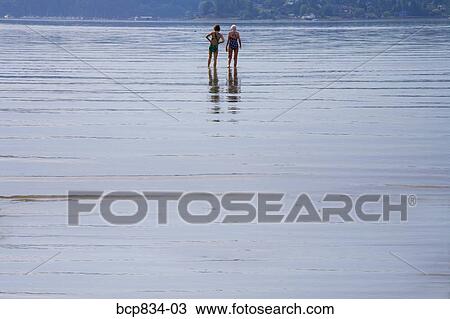 Two women walking in the sea, Washington State, USA View Large Photo Image Stock Image - Two women walking in the sea, Washington State, USA. Fotosearch