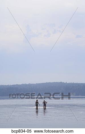 Two women walking in the sea, Washington State, USA View Large Photo Image Stock Photography - Two women walking in the sea, Washington State, USA. Fotosearch