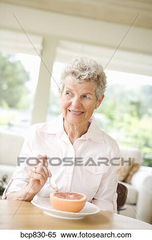 Woman eating a grapefruit View Large Photo Image Stock Photography - Woman eating a grapefruit. Fotosearch