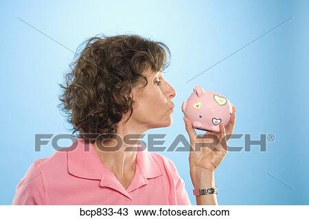 Woman kissing a piggy bank View Large Photo Image Stock Image - Woman kissing a piggy bank. Fotosearch