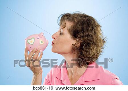 Woman kissing a piggy bank View Large Photo Image Stock Photo - Woman kissing a piggy bank. Fotosearch