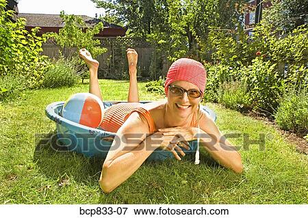 Woman lying in a wading pool and smiling View Large Photo Image Stock Photo - Woman lying in a wading pool and smiling. Fotosearch