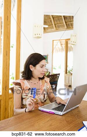 Stock Image - Woman online shopping with a laptop. Fotosearch