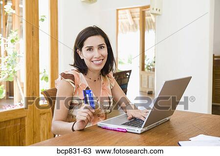 Woman online shopping with a laptop View Large Photo Image Stock Image - Woman online shopping with a laptop. Fotosearch