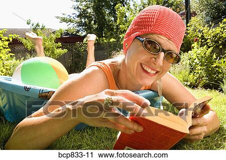 Woman reading a book in a wading pool View Large Photo Image Stock Image - Woman reading a book in a wading pool. Fotosearch