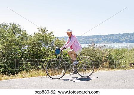 Stock Image - Woman riding a bicycle, Washington State, USA. Fotosearch
