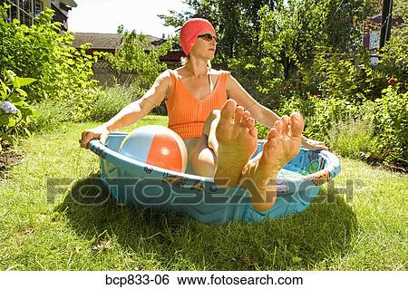 Woman sitting in a wading pool View Large Photo Image Stock Photograph - Woman sitting in a wading pool. Fotosearch