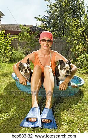 Woman sitting in a wading pool with two Boston Terriers View Large Photo Image Stock Image - Woman sitting in a wading pool with two Boston Terriers. Fotosearch