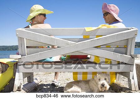 Woman sitting with her mother on a bench View Large Photo Image Stock Photograph - Woman sitting with her mother on a bench. Fotosearch
