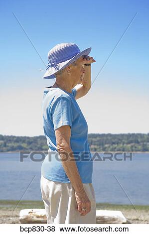 Stock Photo - Woman standing at a beach, Washington State, USA. Fotosearch