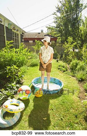 Woman standing in a wading pool View Large Photo Image Stock Photo - Woman standing in a wading pool. Fotosearch