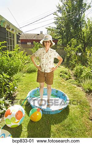 Woman standing in a wading pool with arms akimbo View Large Photo Image Stock Image - Woman standing in a wading pool with arms akimbo. Fotosearch
