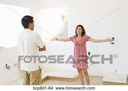Woman standing in front of a man with arm outstretched View Large Photo Image Picture - Woman standing in front of a man with arm outstretched. Fotosearch