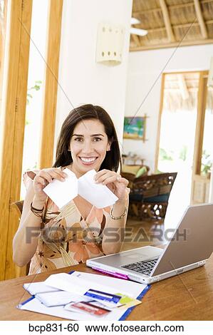 Woman tearing a paper in front of a laptop View Large Photo Image Stock Image - Woman tearing a paper in front of a laptop. Fotosearch