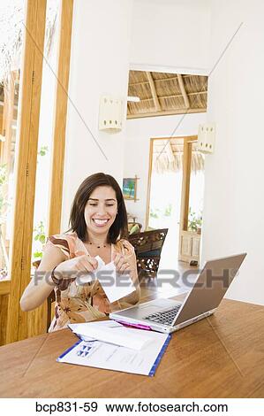 Woman tearing a paper in front of a laptop View Large Photo Image Stock Photo - Woman tearing a paper in front of a laptop. Fotosearch