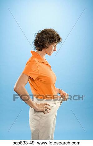 Woman wearing loose pants to show weight loss View Large Photo Image Stock Photo - Woman wearing loose pants to show weight loss. Fotosearch