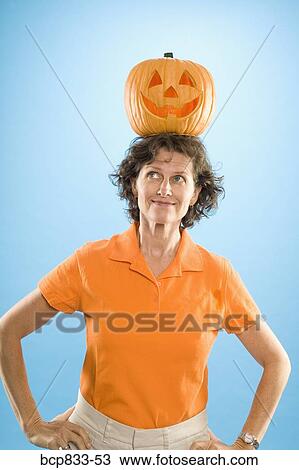 Woman with a Jack O' Lantern over her head View Large Photo Image Stock Image - Woman with a Jack O' Lantern over her head. Fotosearch