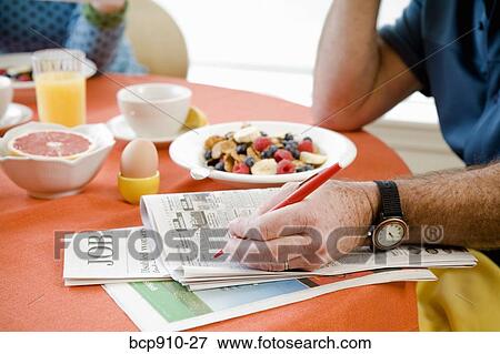 Couple having breakfast and checking classifieds View Large Photo Image Stock Photo - Couple having breakfast and checking classifieds. Fotosearch