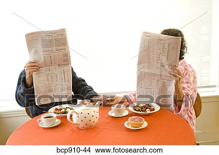 Couple having breakfast and reading newspaper together View Large Photo Image Picture - Couple having breakfast and reading newspaper together. Fotosearch