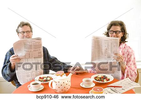 Couple having breakfast and reading newspaper together View Large Photo Image Stock Photograph - Couple having breakfast and reading newspaper together. Fotosearch