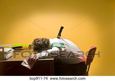 Picture - Deceased man in office stabbed in the back. Fotosearch