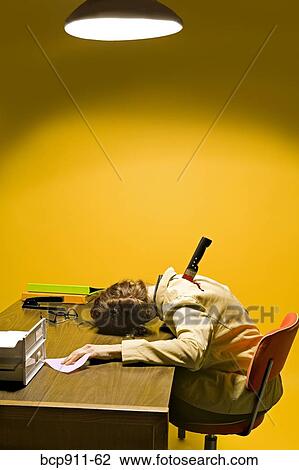 Stock Image - Deceased woman in office stabbed in the back. Fotosearch