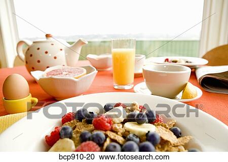 Stock Image - Healthy breakfast of dry cereal and fruit with egg and juice. Fotosearch