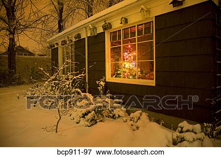 House in winter with Christmas Tree visible in window View Large Photo Image Stock Photo - House in winter with Christmas Tree visible in window. Fotosearch