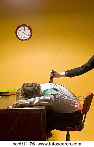 Stock Photograph - Man in office being stabbed in the back. Fotosearch