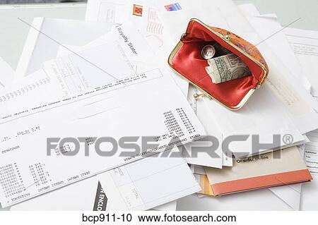 Stock Image - Open coin purse on pile of bills. Fotosearch