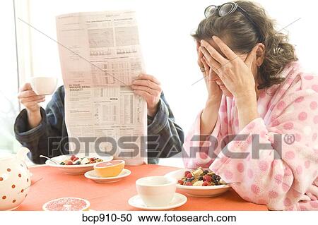 Stock Image - Tired woman with her husband having breakfast. Fotosearch