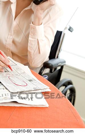 Stock Image - Woman in a wheelchair at breakfast talking on phone. Fotosearch