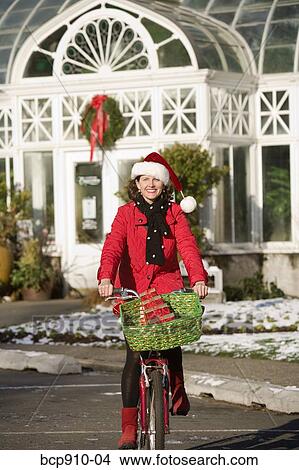 Woman in Christmas attire on a bicycle ride View Large Photo Image Picture - Woman in Christmas attire on a bicycle ride. Fotosearch