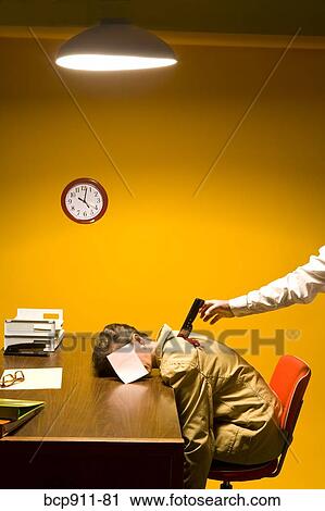 Stock Image - Woman in office being stabbed in the back. Fotosearch