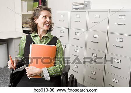 Woman in wheelchair holding files View Large Photo Image Stock Photo - Woman in wheelchair holding files. Fotosearch
