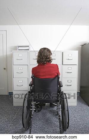 Woman in wheelchair in front of file cabinet View Large Photo Image Picture - Woman in wheelchair in front of file cabinet. Fotosearch