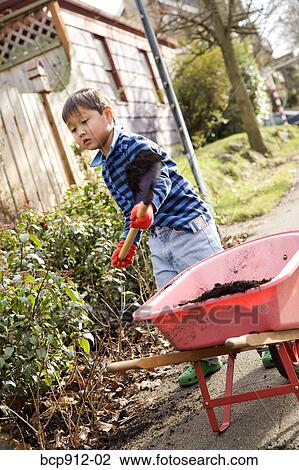 Young boy digging in garden with spade View Large Photo Image Stock Image - Young boy digging in garden with spade. Fotosearch