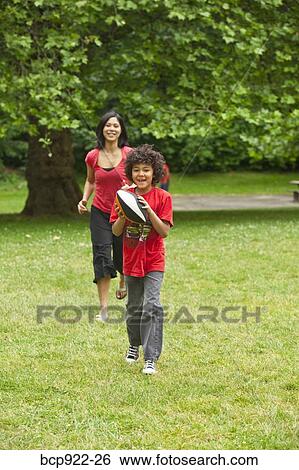 Boy with football running from mother View Large Photo Image Stock Photograph - Boy with football running from mother. Fotosearch