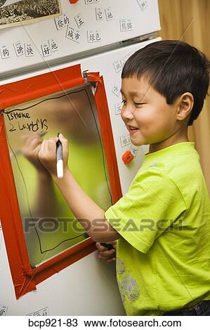 Boy writing on kitchen memo board View Large Photo Image Stock Image - Boy writing on kitchen memo board. Fotosearch