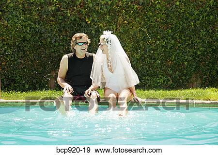 Stock Photo - Bride and groom in swimming pool. Fotosearch