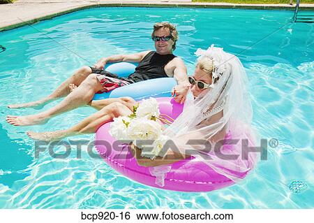 Bride and groom in swimming pool View Large Photo Image Stock Photograph - Bride and groom in swimming pool. Fotosearch