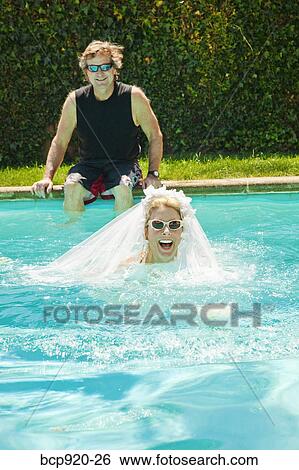 Stock Photograph - Bride and groom in swimming pool. Fotosearch