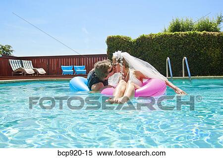 Bride and groom in swimming pool View Large Photo Image Stock Photography - Bride and groom in swimming pool. Fotosearch