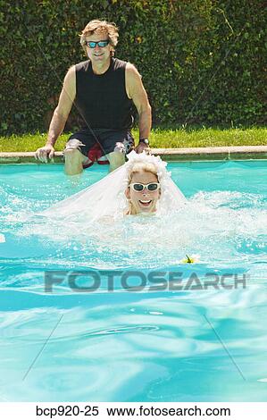 Bride and groom in swimming pool View Large Photo Image Stock Photography - Bride and groom in swimming pool. Fotosearch
