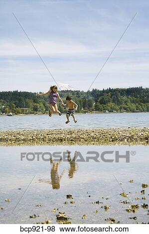 Children jumping on beach View Large Photo Image Stock Photo - Children jumping on beach. Fotosearch