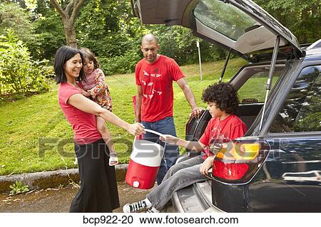 Stock Image - Family getting picnic items out of car. Fotosearch