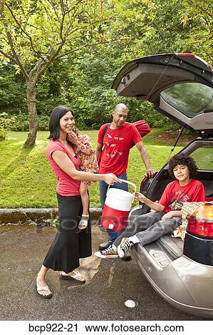Stock Image - Family getting picnic items out of car. Fotosearch