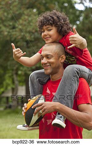 Stock Photograph - Father holding son outdoors. Fotosearch