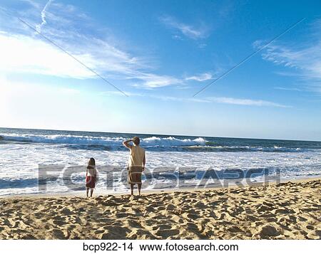 Man and girl looking at surf View Large Photo Image Picture - Man and girl looking at surf. Fotosearch