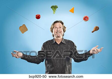 Stock Image - Man juggling different foods. Fotosearch